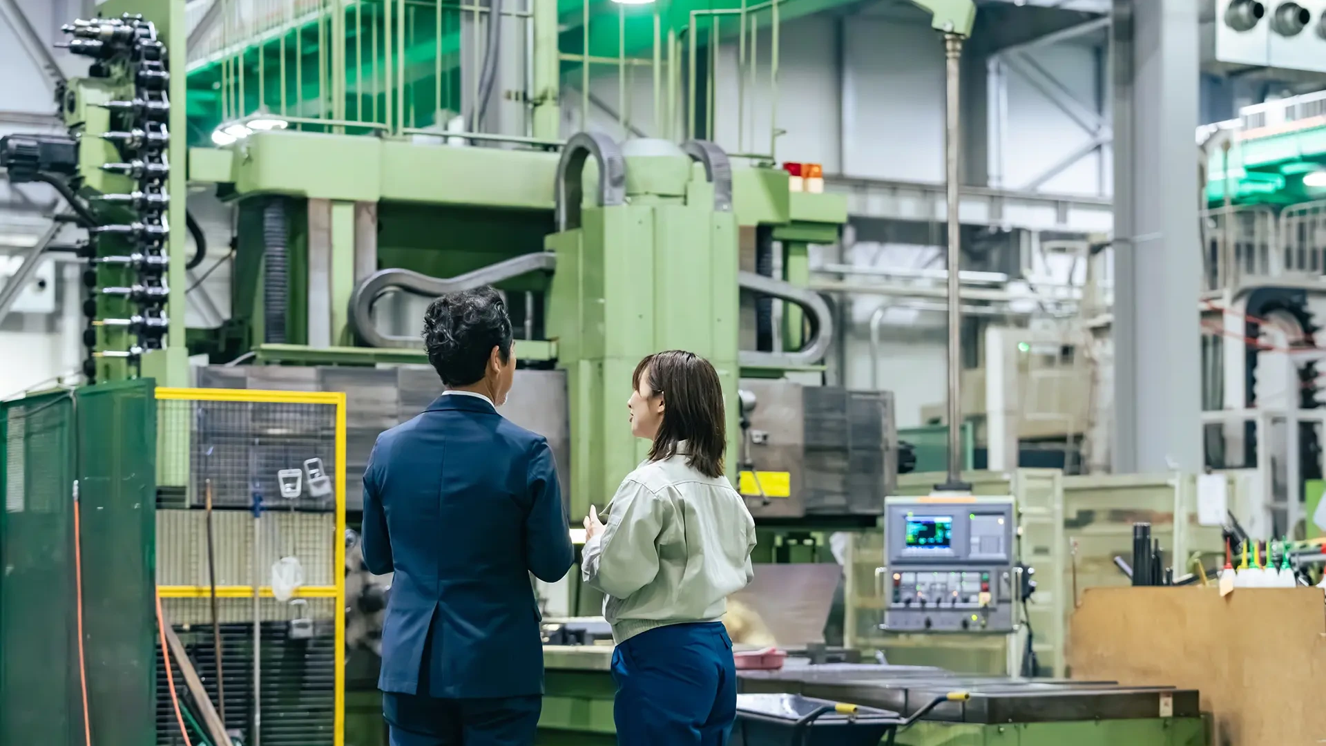 工場設備について説明を受ける企業担当者